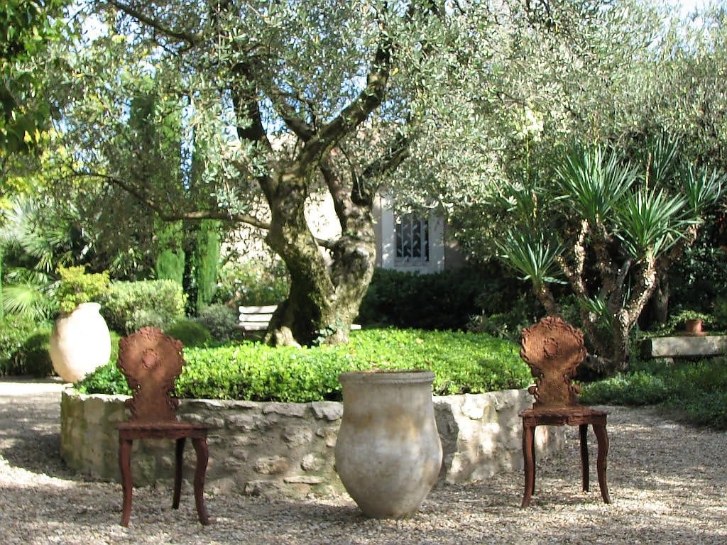 coin repos aménagé dans un jardin avec mobilier confortable et verdure