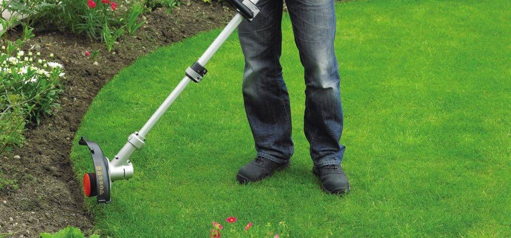 Coupe-bordure prêt à l'emploi dans un jardin bien entretenu
