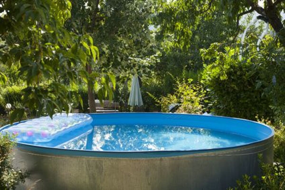 Habillage esthétique d'une piscine tubulaire en bois et panneaux synthétiques