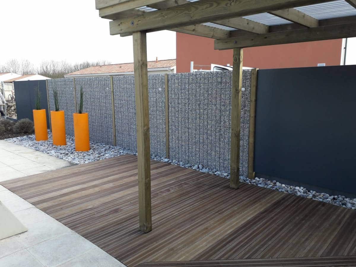 Murs en gabion intégrés dans un jardin verdoyant avec plantes et fleurs colorées