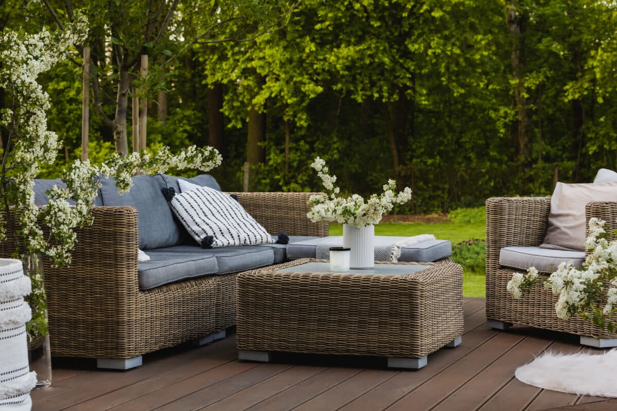 jardin contemporain avec terrasse en osier et végétation soignée
