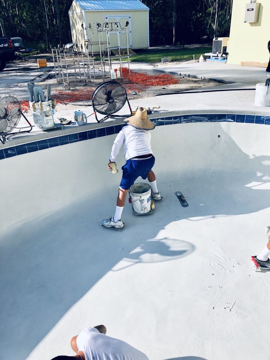 ouvrier finalisant une piscine en béton résistante