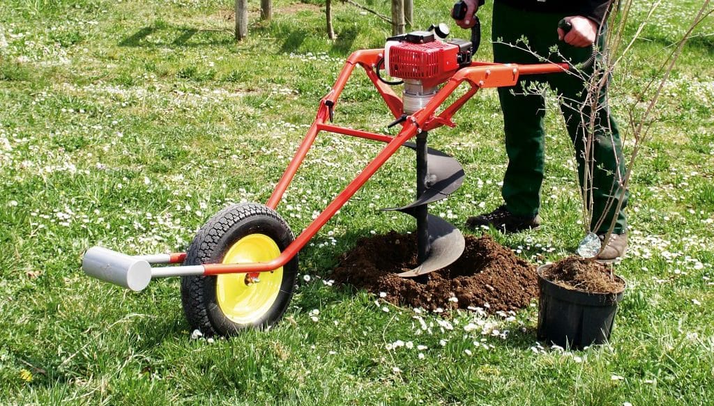 Tarière thermique utilisée pour creuser dans un jardin